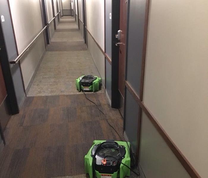 Long carpeted hallway with two air movers.