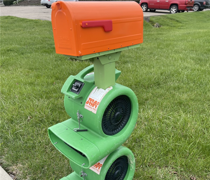 Orange mail box with two green air blowers