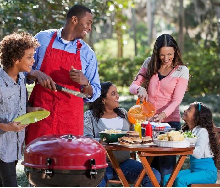 Diverse family having a cookout, smiling at each other